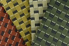 four different colored ties with black, white and green designs on them are lined up in rows