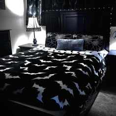 a bed with black and white bedspread in a dark room