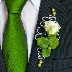 a man wearing a suit and tie with a boutonniere on his lapel