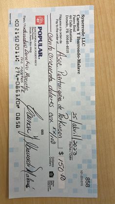 two checks are sitting on top of a wooden table