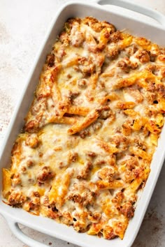 a casserole dish with meat and cheese in it on a white table top