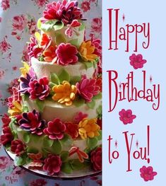 a three tiered cake is decorated with flowers and the words happy birthday to you