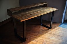 a wooden table sitting on top of a hard wood floor next to a metal frame