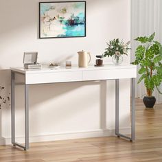 a white table with some plants on top of it and a potted plant next to it