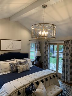 a bedroom with a large bed and chandelier