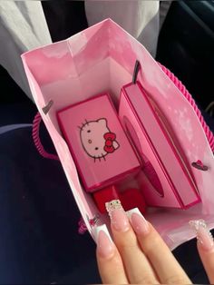 a pink hello kitty lunch box with some nail polish on it