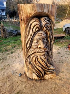 a carved wood stump with a man's face and beard on the top of it