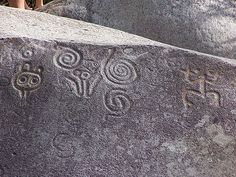 some rocks with carvings on them in the grass