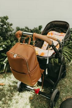 a brown backpack sitting on top of a stroller