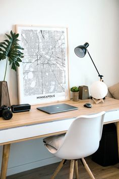 a white desk topped with a laptop computer next to a plant and a potted plant