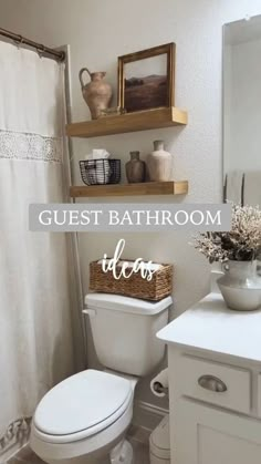 a white toilet sitting in a bathroom next to a sink and shower curtain with the words guest bathroom decor above it