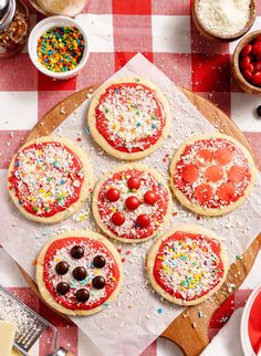 four pizzas with toppings are on a checkered tablecloth and ready to be eaten