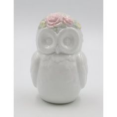 an owl figurine with flowers on it's head is sitting in front of a white background