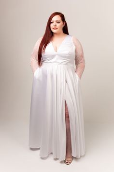 a woman with long red hair wearing a white dress