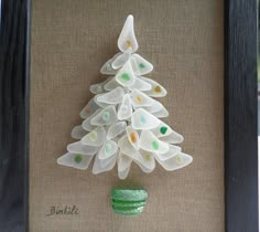 a small glass christmas tree in a frame