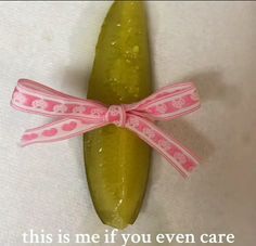 a cucumber with a pink ribbon tied around it and the words, this is me if you even care