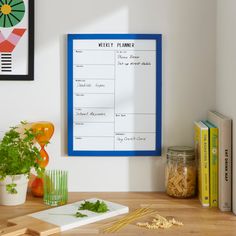 a wooden table topped with lots of food and veggies next to a white board