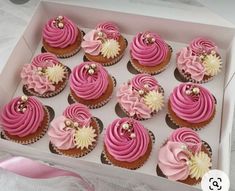 twelve cupcakes with pink frosting in a box