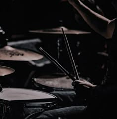 a man is playing drums in the dark