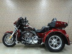 a red motorcycle parked in front of a brick wall