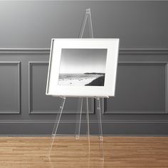 an easel with a black and white photo on it in front of a gray wall