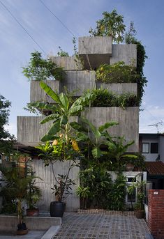 a tall building with many plants growing on it's sides and in the middle