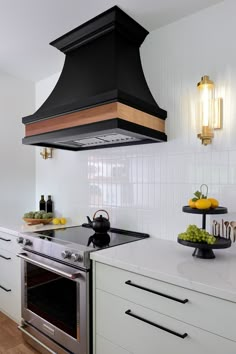 a stove top oven sitting inside of a kitchen next to a counter with fruit on it