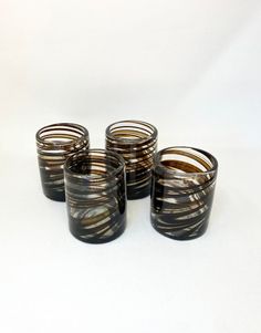 four black and brown glass cups sitting on top of each other