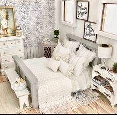 a bedroom with white furniture and wallpaper on the walls