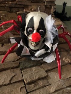 a creepy clown mask hanging on a brick wall