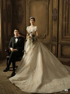 a man and woman in formal wear posing for a photo together on a wooden floor