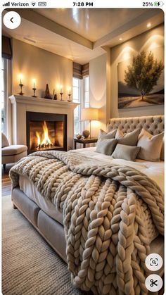 a bedroom with a bed, fireplace and pictures on the wall above it that are framed in white frames