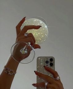 two hands holding wine glasses and an iphone