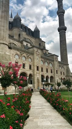 a large building with two towers and flowers in the foreground