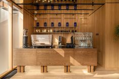 a coffee bar with lots of bottles on the wall and shelves in front of it