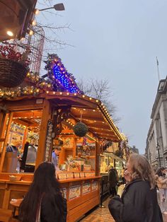 people are walking around an outdoor christmas market