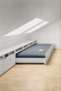 a bed in the middle of a room under a slanted roof