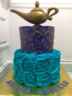 a blue and gold cake with a teapot on top