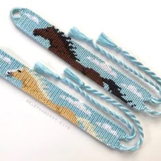 two pieces of beaded fabric with horses on them, one is blue and the other is brown