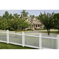 a white picket fence in front of a large house