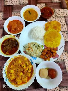 several different types of food are on the table with rice, beans and sauces