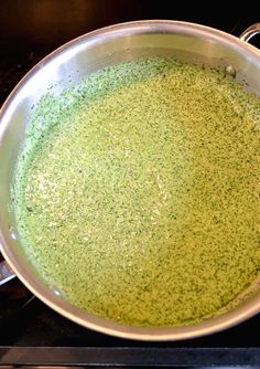 a pan filled with green liquid sitting on top of a stove