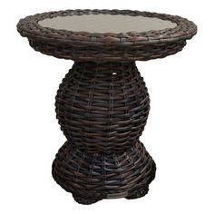 a wicker table with glass top on an isolated white background for use in interior or exterior decor