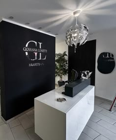 a white counter in front of a black and white wall with the words gldl on it