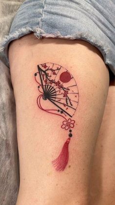 a woman's thigh with a clock and tassel tattoo on her left leg