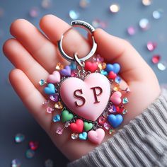 a person holding a heart shaped keychain with the letter s on it