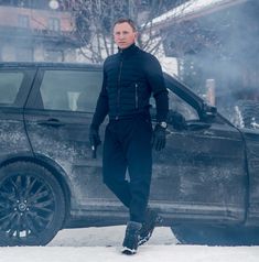 a man standing next to a car in the snow