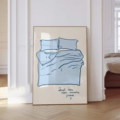 a blue and white bed sitting next to a window in a room with wooden floors