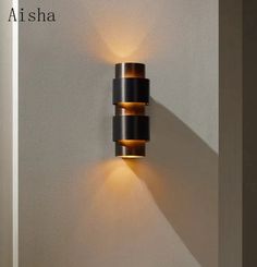 a wall light that is on the side of a wall with two lights in it