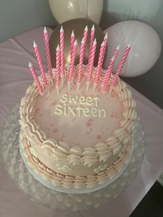 a birthday cake with pink candles on it and the words sweet sixteen written in frosting